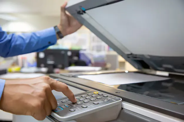 Impresora de la copistería con papel y sobres en Sabiñánigo